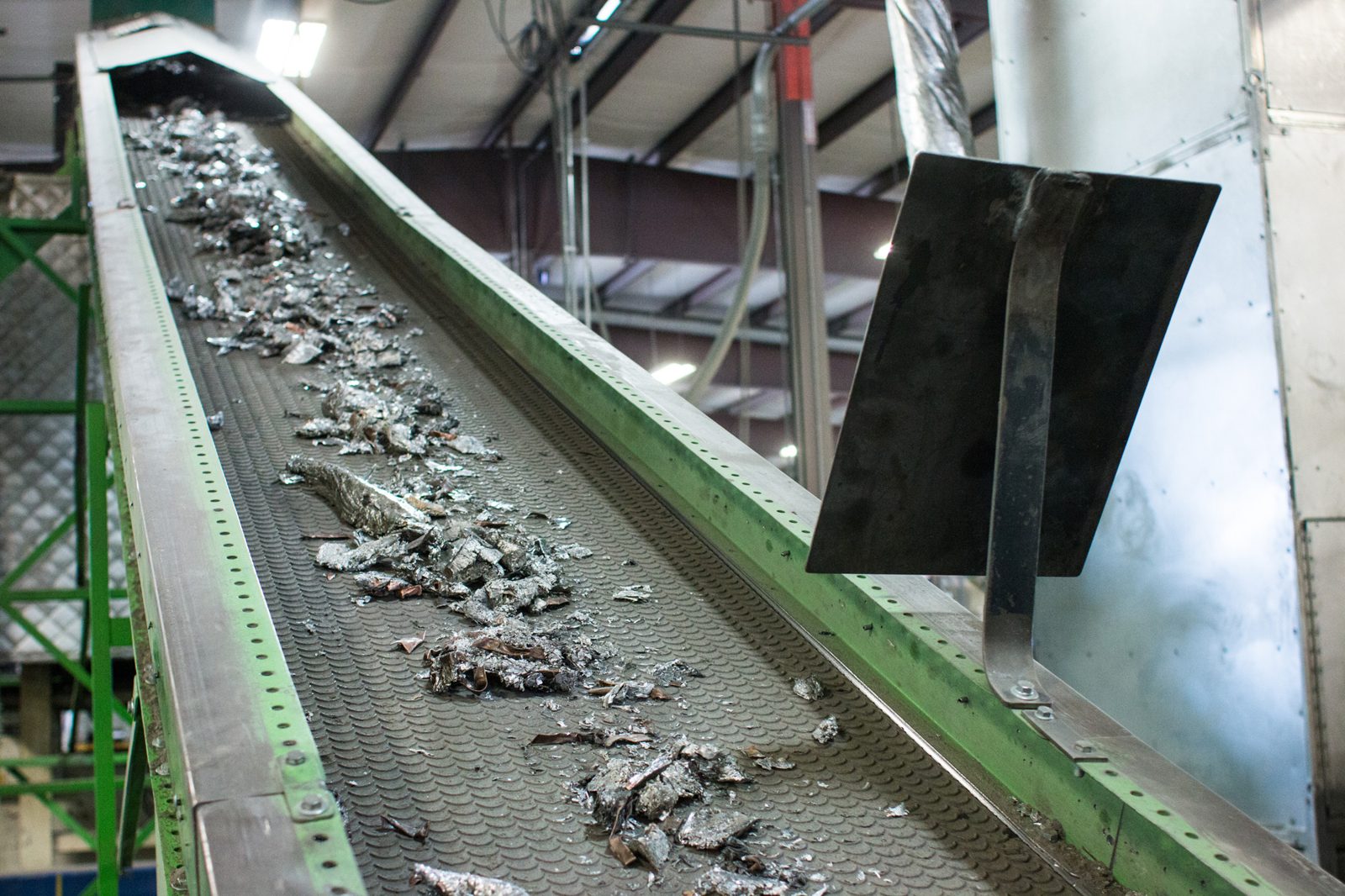 Shredded non-ferrous metal moving up a conveyor inside the SIC processing plant